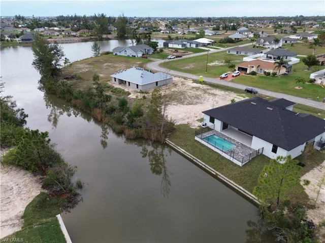 Birds eye view of property with a water view
