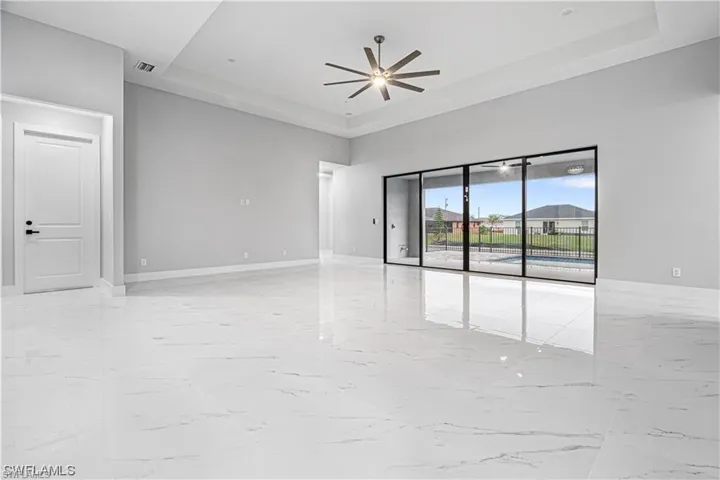 Spare room with a towering ceiling, ceiling fan, and a raised ceiling