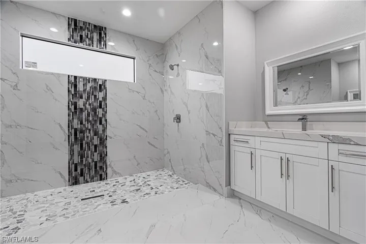 Bathroom with vanity and tiled shower