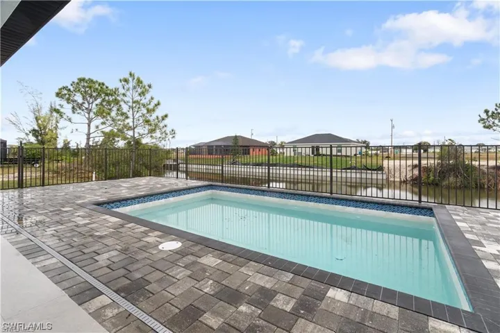 View of swimming pool featuring a patio and a water view