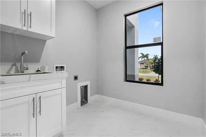 Laundry area with washer hookup, cabinets, sink, and electric dryer hookup