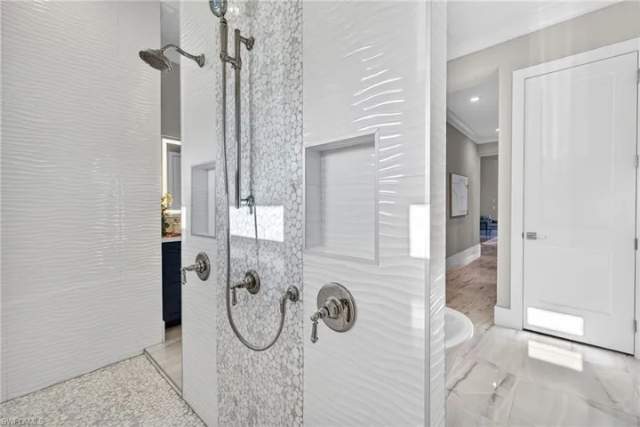 Bathroom view of a shower stall and ornamental molding