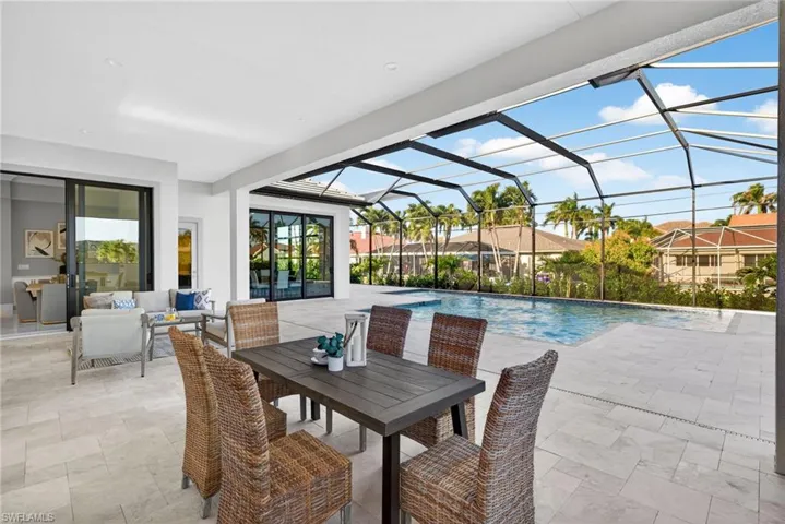 Outdoor pool with a patio area, a sunroom, glass enclosure, an outdoor hangout area, and outdoor dining area