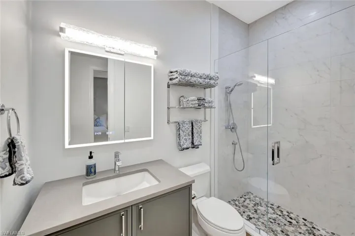Full Guest Bathroom with Framless glass shower, Designer light fixture, and floating vanity.