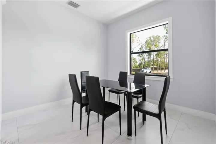 Bright interior space featuring light-toned walls and large format tile flooring