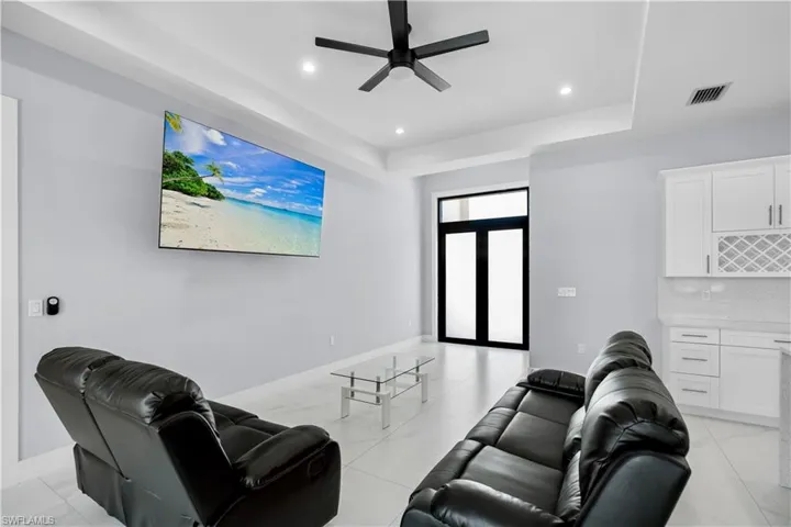 Open-concept living space featuring sleek tile flooring, recessed lighting, and a modern ceiling fan