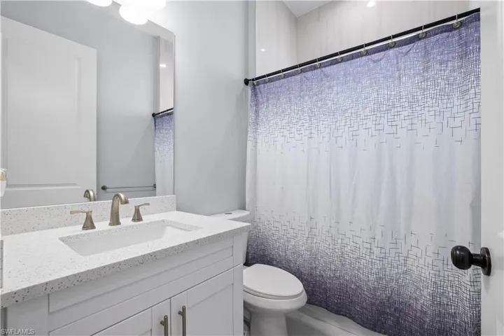 Bathroom featuring a vanity with an integrated sink, a speckled countertop, and brushed nickel fixtures