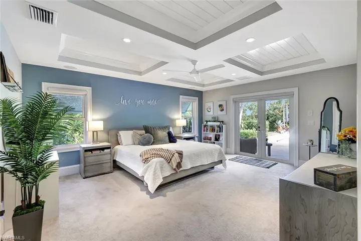 Carpeted bedroom with a raised ceiling, ceiling fan, access to exterior, crown molding, and french doors
