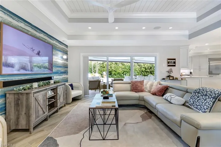 Living room featuring ornamental molding, light hardwood / wood-style flooring, wood ceiling, and a tray ceiling