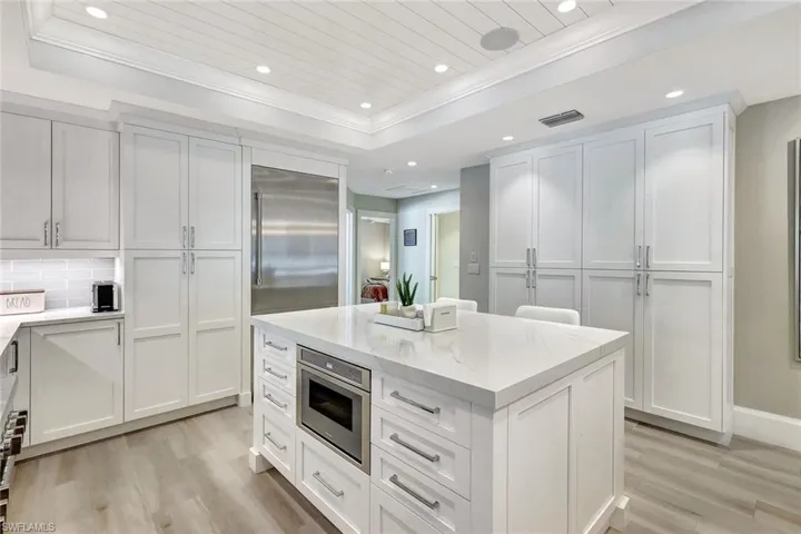 Kitchen with white cabinets, tasteful backsplash, stainless steel appliances, and a raised ceiling