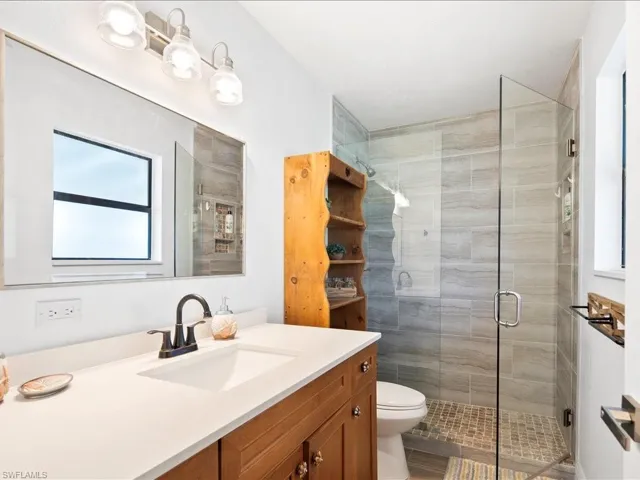 Bathroom with plenty of natural light, vanity, and a shower stall
