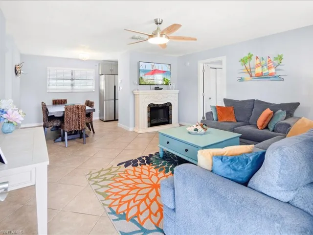 Living area with light tile patterned floors, a premium fireplace, and ceiling fan
