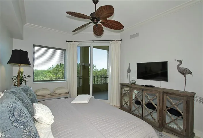 Bedroom with ceiling fan, ornamental molding, and access to exterior