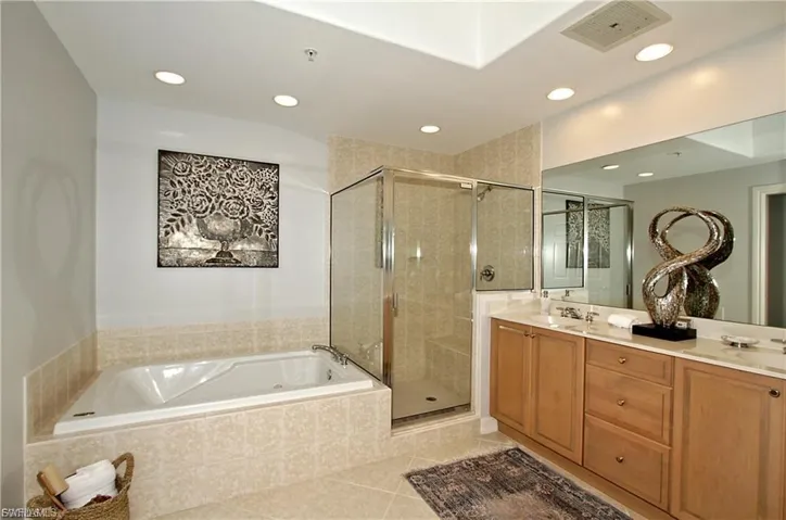 Bathroom with double vanity, a garden tub, a shower stall, light tile patterned floors, and recessed lighting