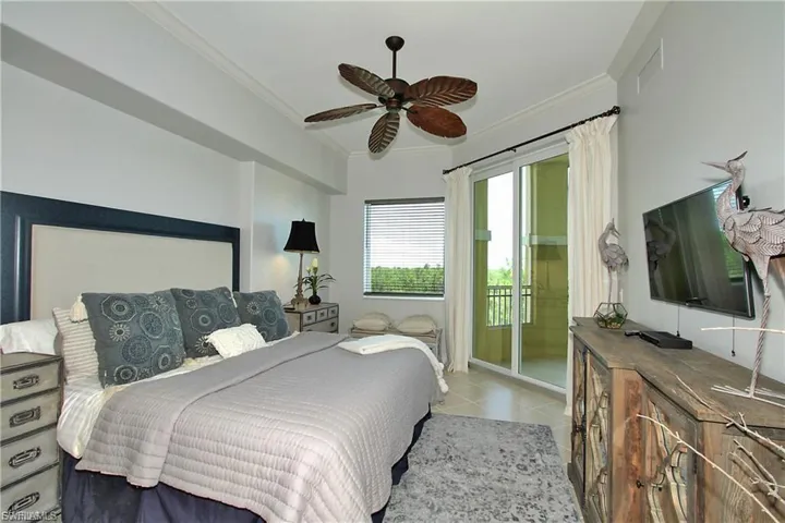 Bedroom with ornamental molding, ceiling fan, and access to outside