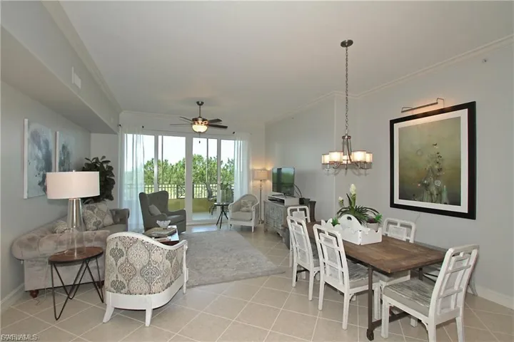 Dining space featuring ceiling fan, crown molding, hanging lights, and light tile patterned floors