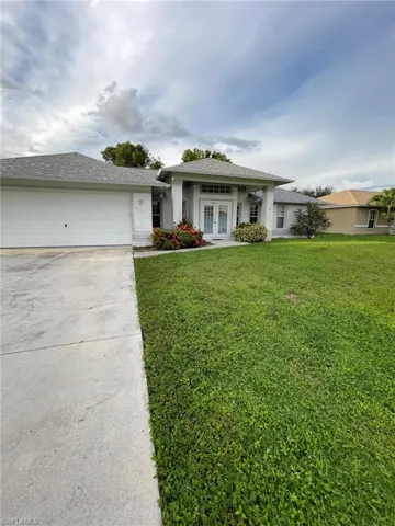 View of front facade with a garage and a front lawn