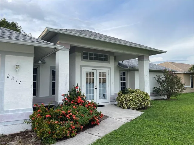 Entrance to property featuring a lawn and french doors
