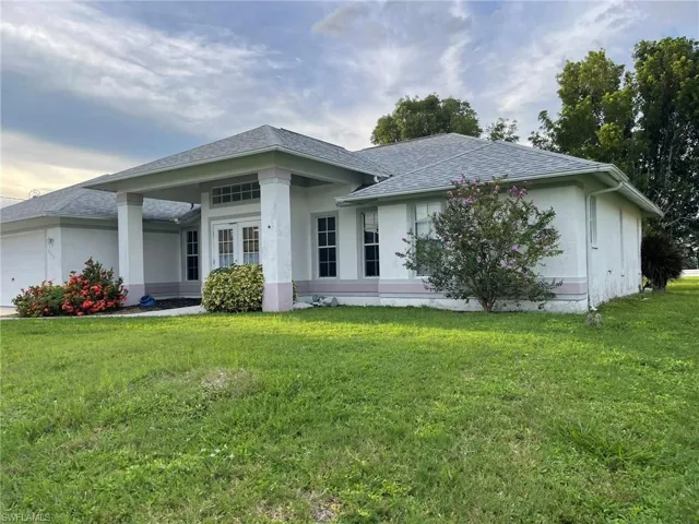 View of front facade featuring a front lawn and a garage