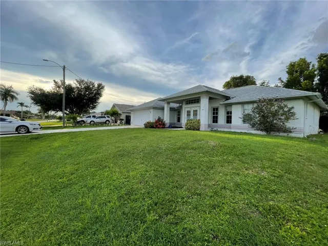 View of front of house featuring a garage and a front yard