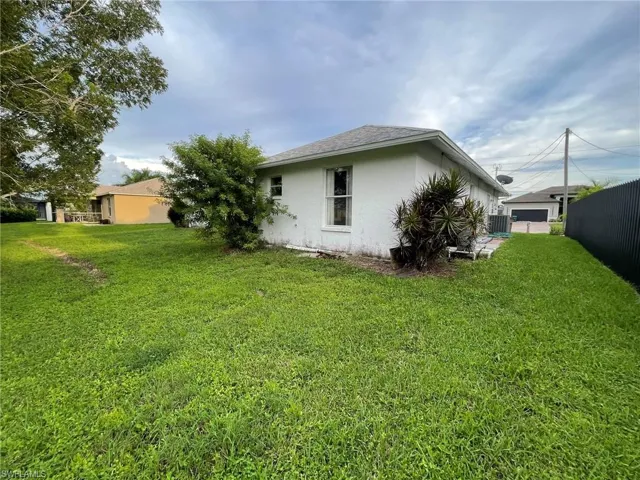 View of property exterior featuring central AC and a lawn