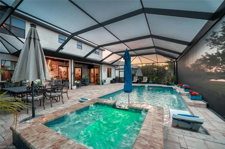 View of pool with a sunroom, a patio area, a lanai, and a pool with connected hot tub