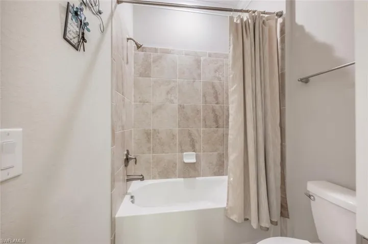 #2 Bathroom with shower / bath combo with shower curtain and toilet