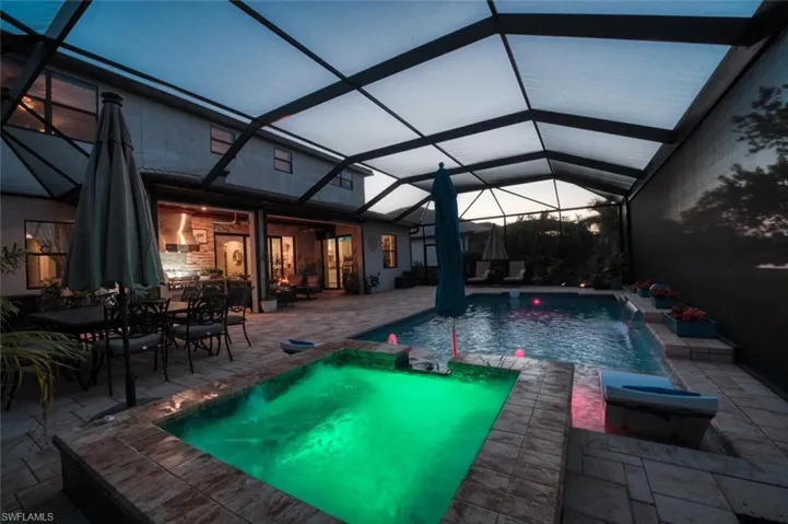 View of swimming pool with a sunroom, a lanai, a patio, and a pool with connected hot tub