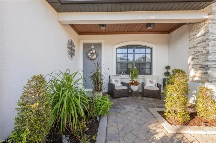 View of exterior entry with stucco siding and a porch