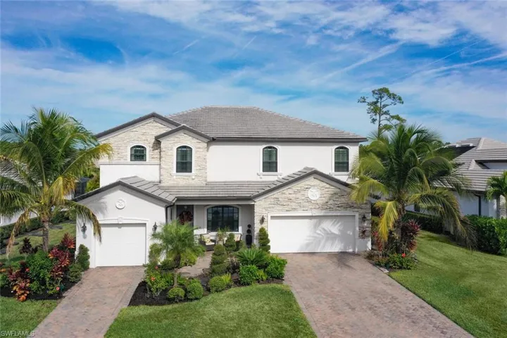 French provincial home with stone siding, stucco siding, and decorative driveway