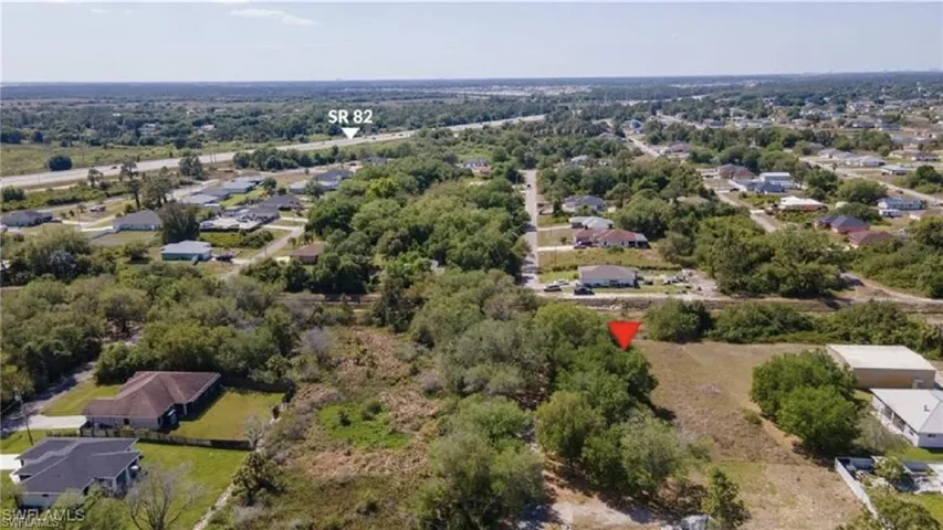 Aerial view of property and surrounding area featuring nearby suburban area