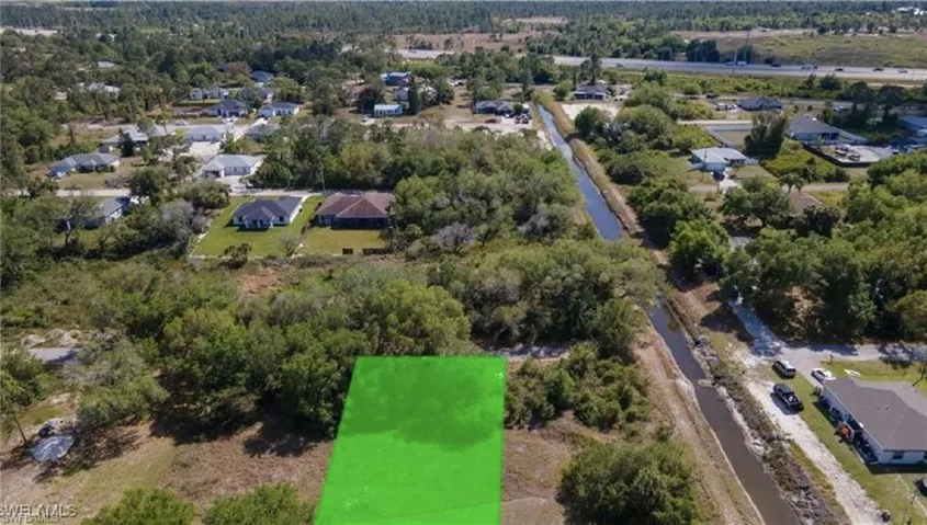 Aerial view of property and surrounding area featuring nearby suburban area
