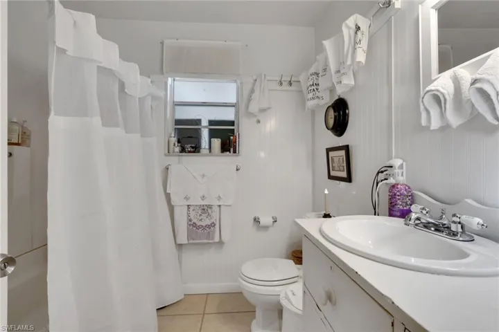 Full bath with vanity, light tile patterned floors, and a shower/tub