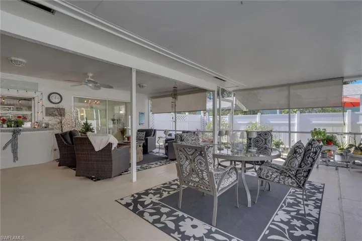 Covered patio area with pass through kitchen window; pull down shades can be used to block sun, wind or rain as needed