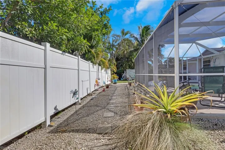 Graveled area between pool cage and property fence