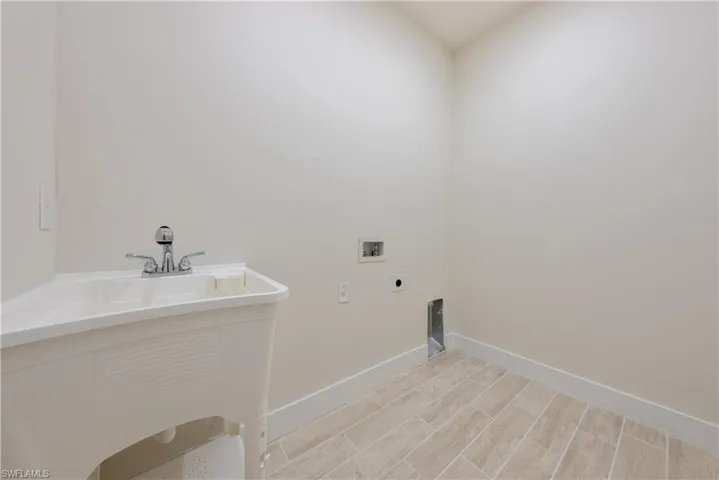 Laundry area with hookup for a washing machine, hookup for an electric dryer, and wood finish floors