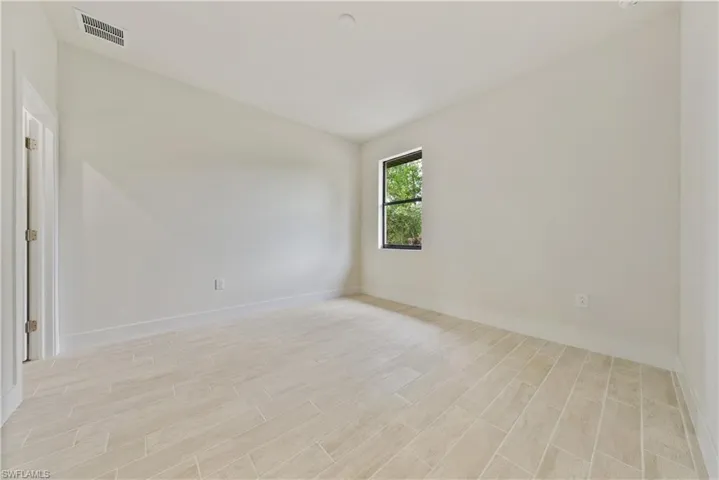 Unfurnished room with wood finish floors and lofted ceiling