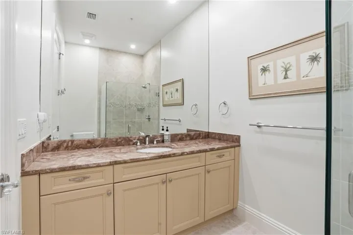 Bathroom with a shower stall, vanity, light tile patterned floors, and recessed lighting