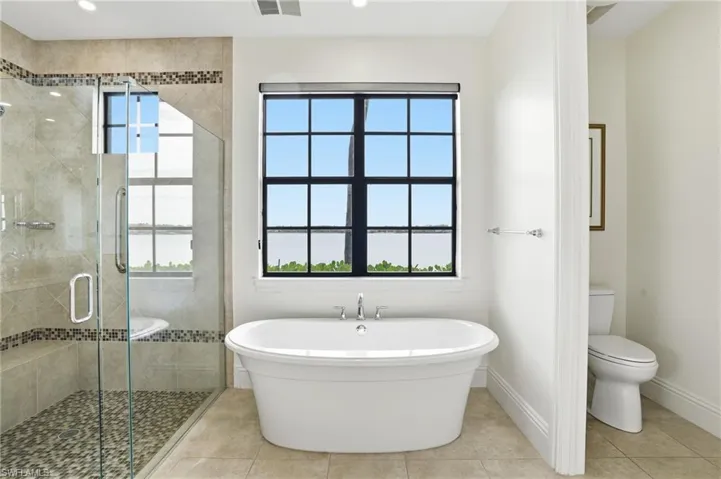 Bathroom featuring a stall shower, a soaking tub, and tile patterned floors