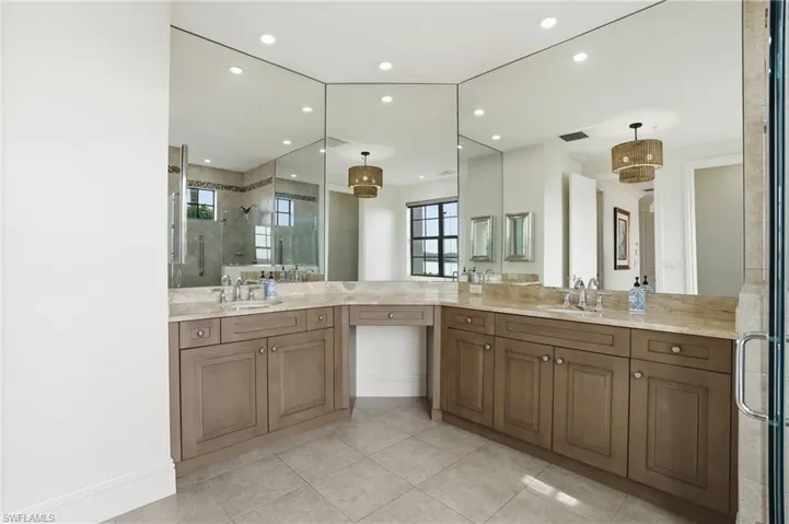 Bathroom featuring a stall shower, vanity, light tile patterned floors, and recessed lighting