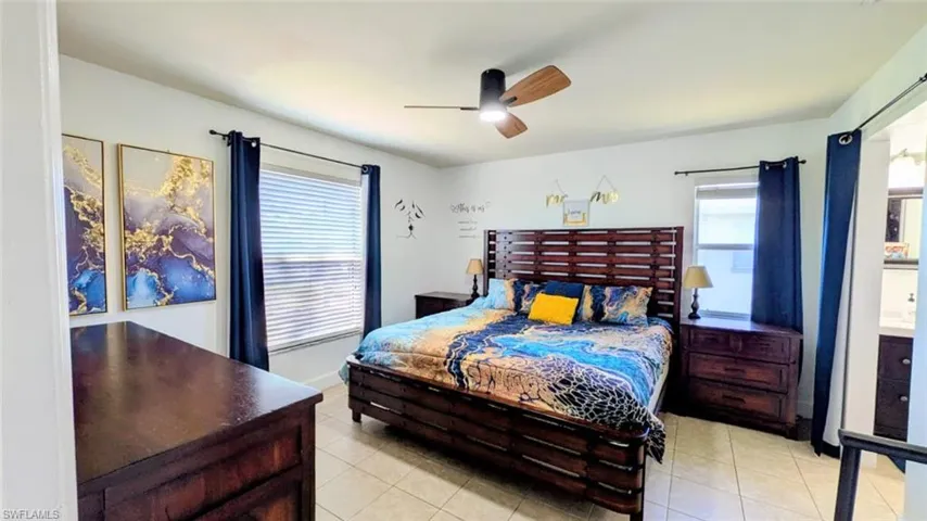 Bedroom with ceiling fan and light tile patterned flooring