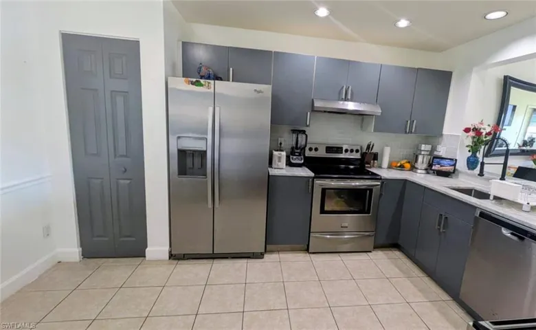 Kitchen with stainless steel appliances, backsplash, recessed lighting, gray cabinets, and light tile patterned flooring