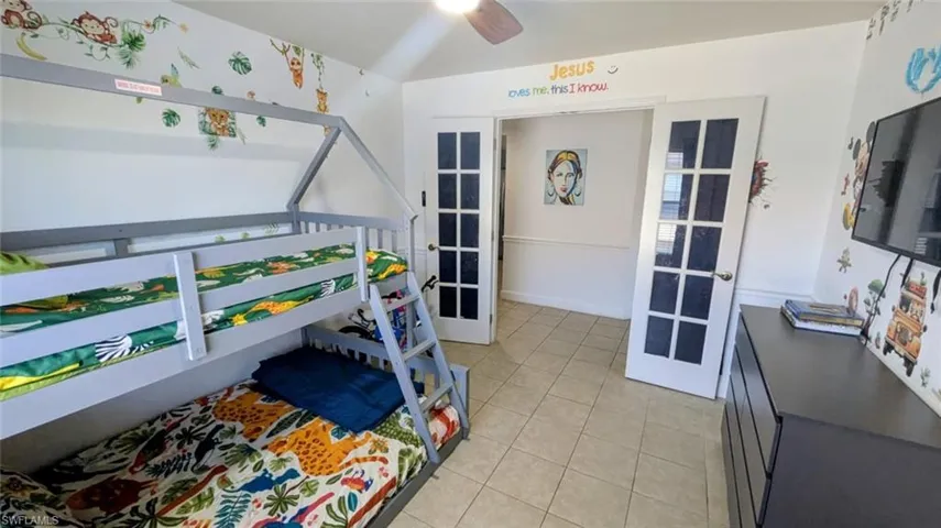 Bedroom featuring french doors, light tile patterned floors, and ceiling fan