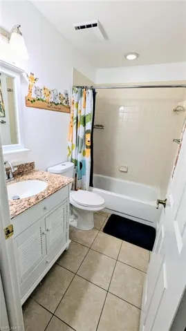 Bathroom with vanity, shower / tub combo, light tile patterned flooring, and recessed lighting