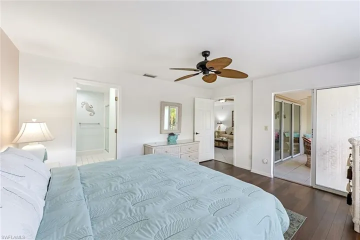 Bedroom featuring ensuite bath, dark wood finished floors, ceiling fan, and a closet