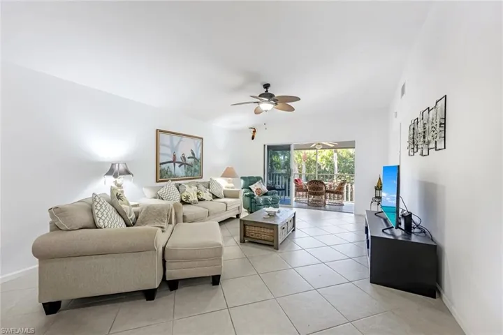 Living area with a ceiling fan and light tile patterned floors