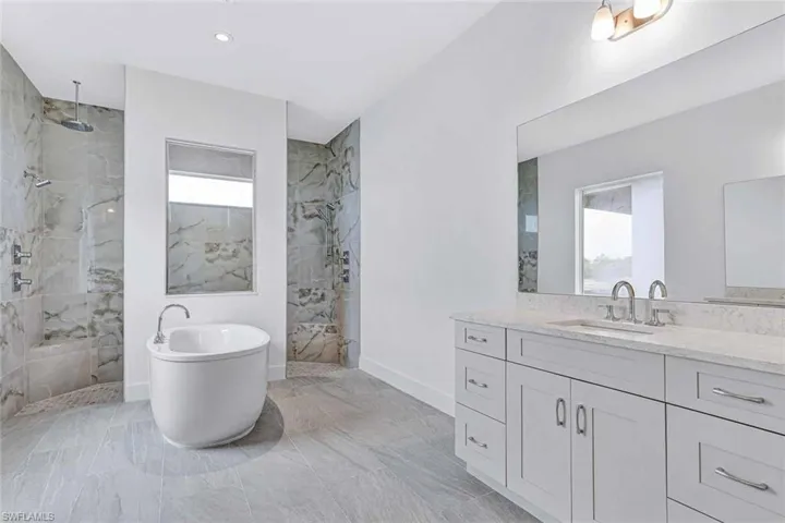Primary bathroom with dual-sinks, quartz countertops, soft-close cabinetry, and luxe walk-in shower