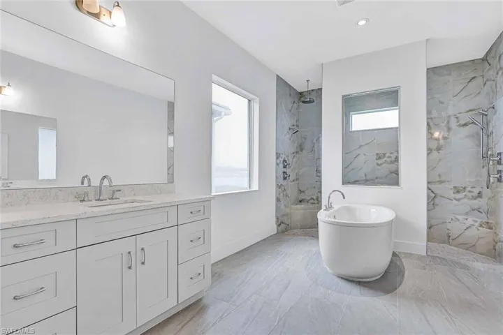 Primary bathroom with dual-sinks, quartz countertops, soft-close cabinetry, and luxe walk-in shower