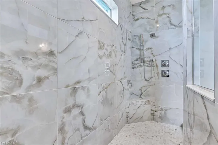 Free-standing, Kohler tub with dual-shower heads in luxe, primary bathroom shower