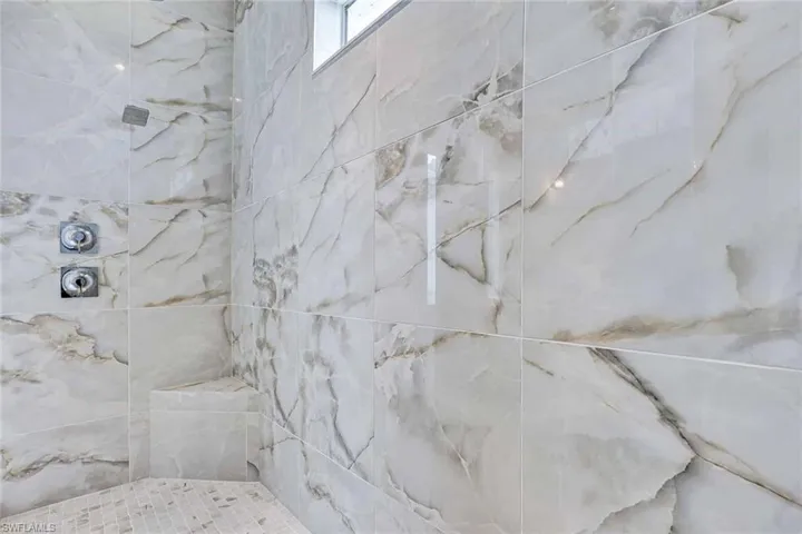 Free-standing, Kohler tub with dual-shower heads in luxe, primary bathroom shower